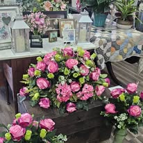 Pink rose casket arrangement on a wooden chest