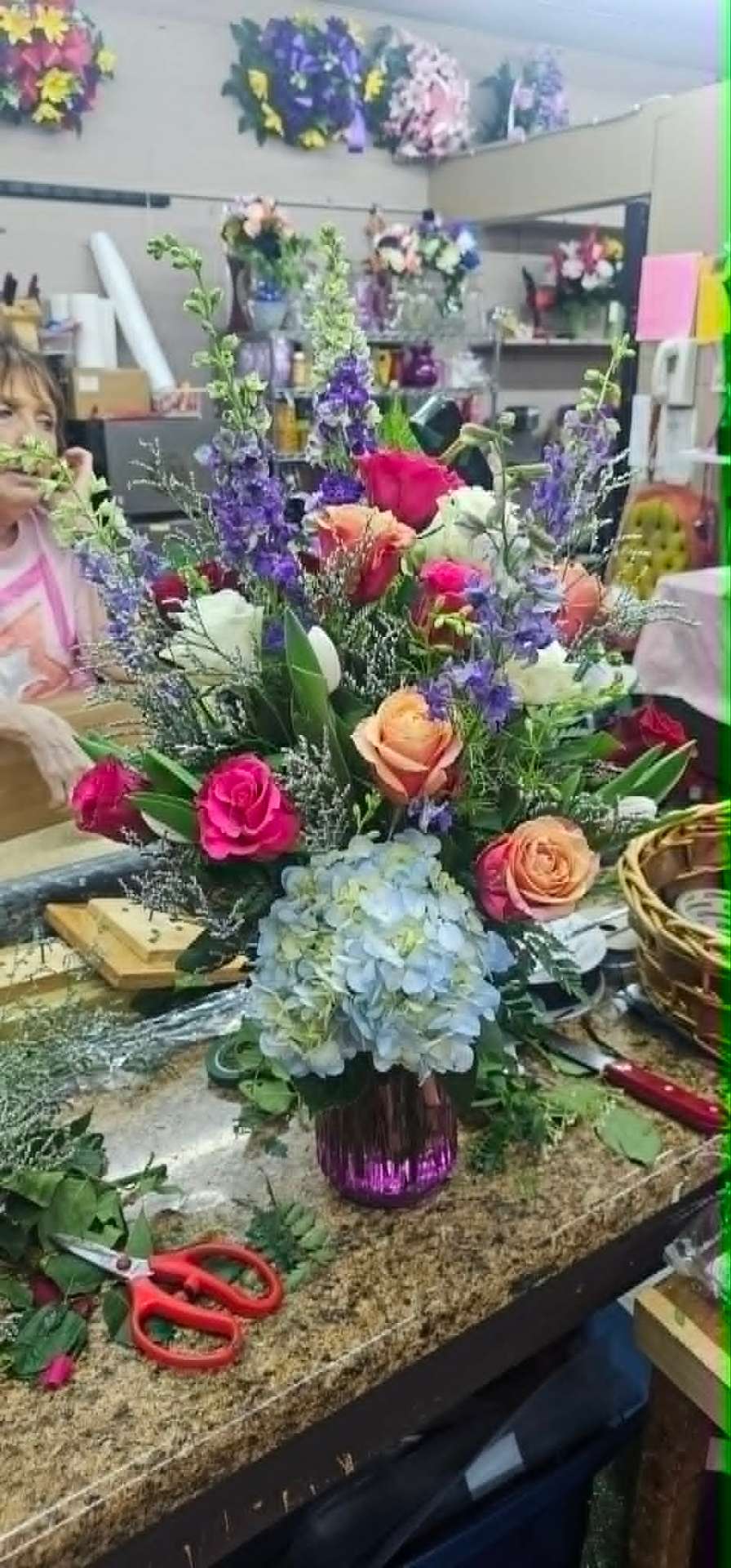 Colorful arrangement with roses, delphinium, and hydrangea