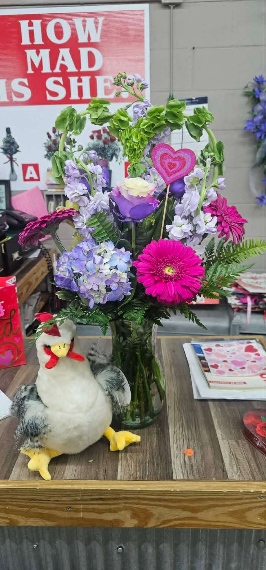 Valentine bouquet with hot pink gerberas, purple roses, and bells of Ireland