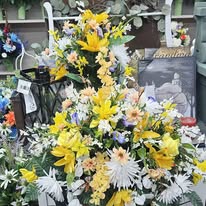 Yellow lily and white daisy standing memorial spray