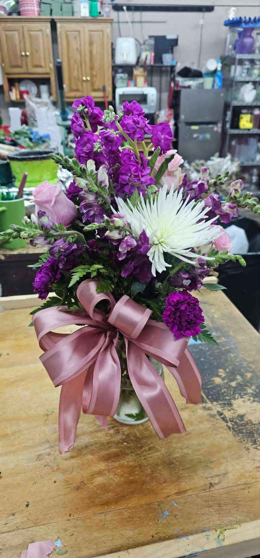 Purple stock and white spider mum bouquet with mauve ribbon